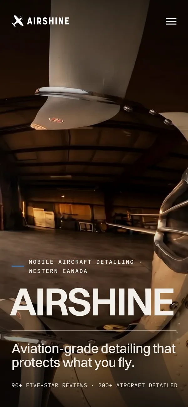 The Airshine homepage on a phone, over a polished propeller in the hangar.